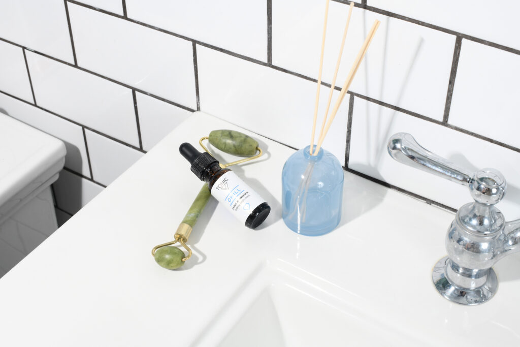 Chill TONIC cbd tincture in bathroom with jade roller and reed diffuser