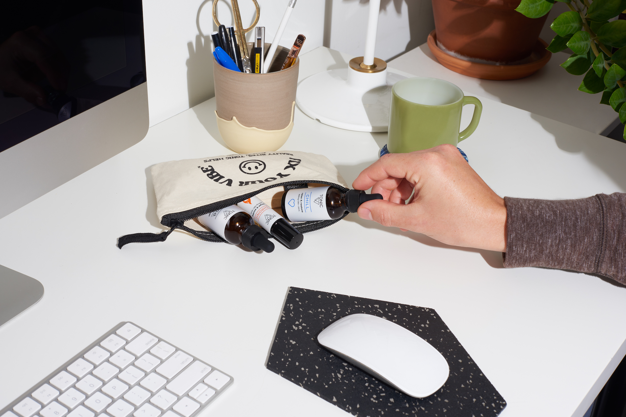 good vibe tribe on desk pulling out Chill TONIC from pouch