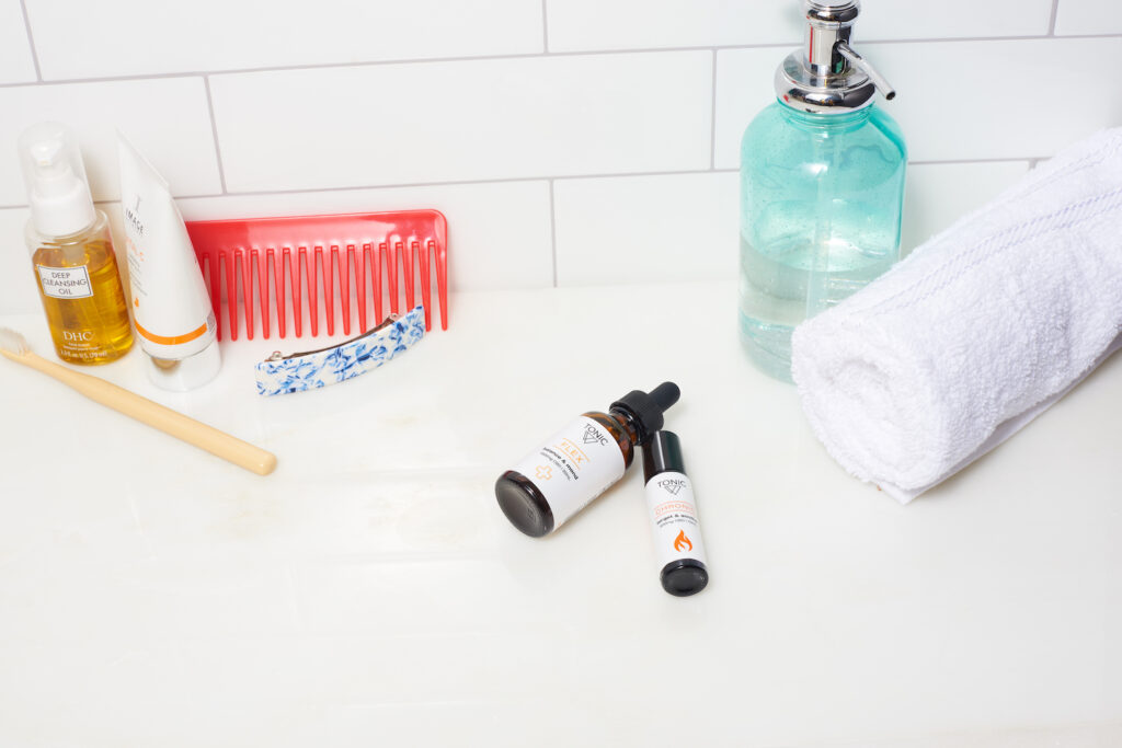 TONIC CBD Flex and Chronic laying on bathroom counter with toiletries