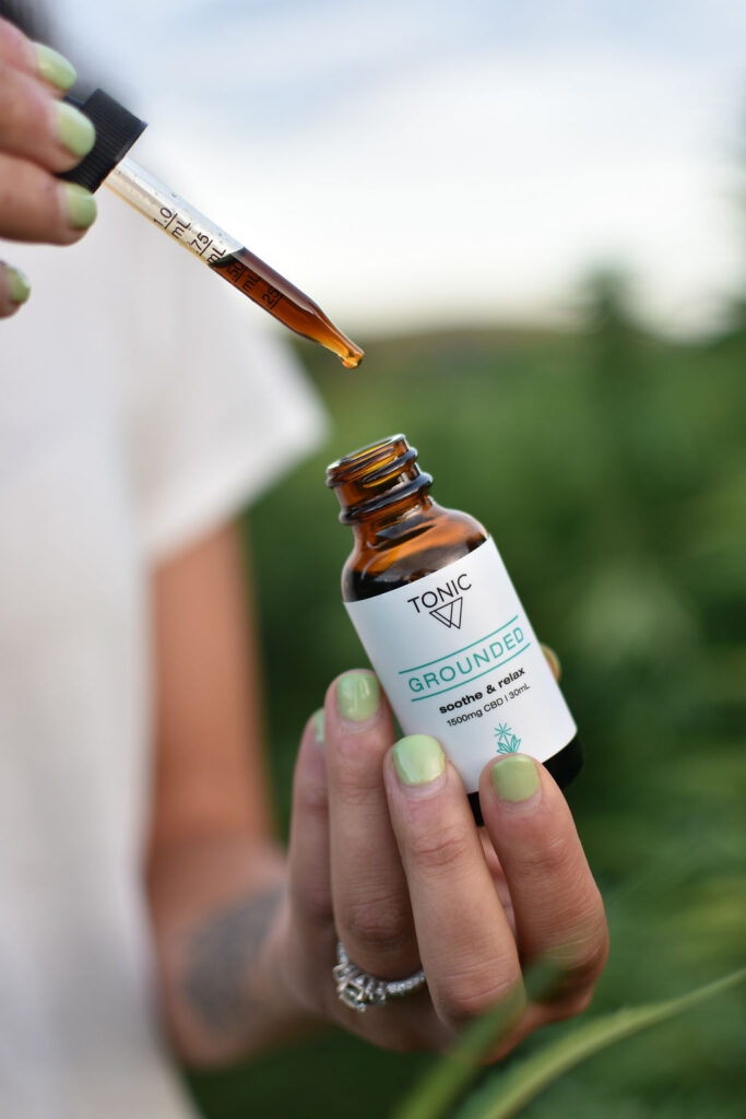 Holding bottle of Grounded TONIC on Tricolla Farms, Berkshire, NY