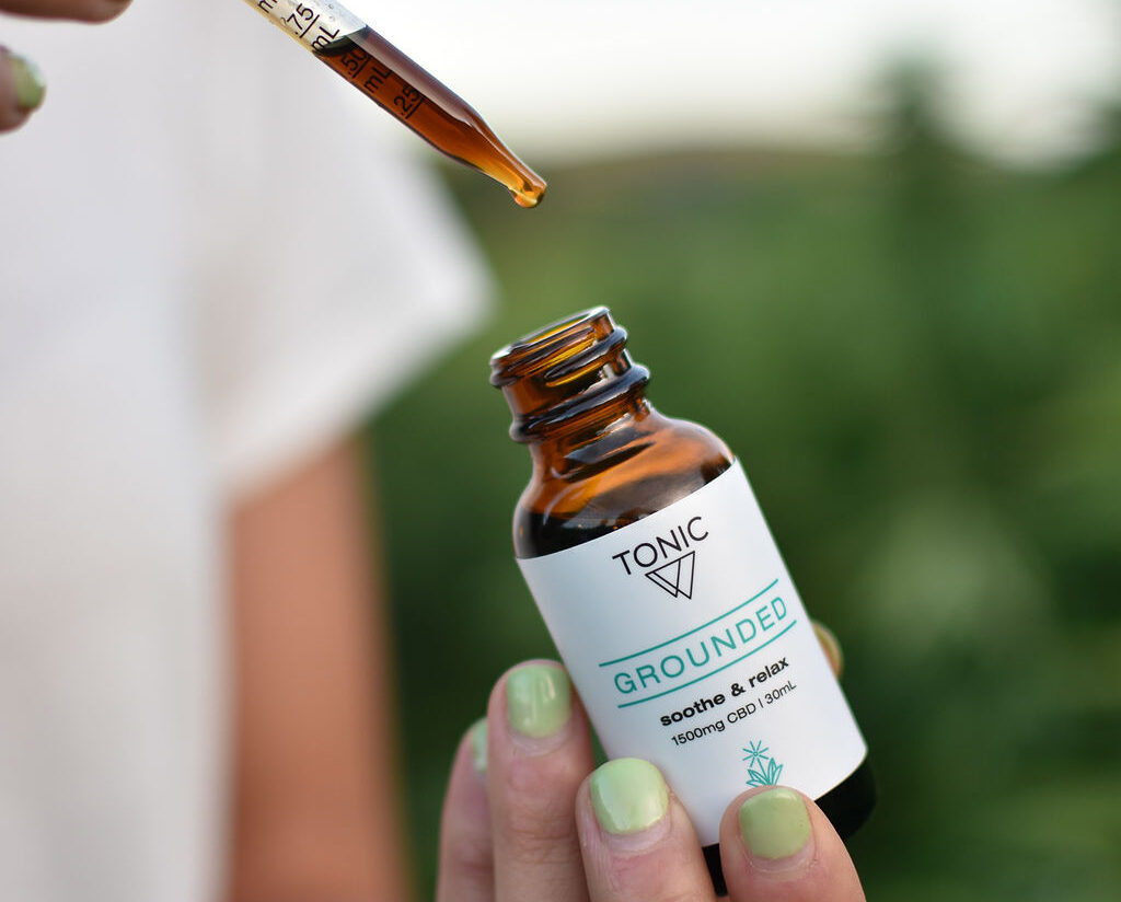 Holding bottle of Grounded TONIC on Tricolla Farms, Berkshire, NY